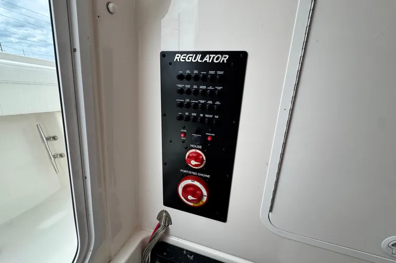 Slide: The Image of Control panel of a 2022 Regulator 28 boat with switches and dials. - 66