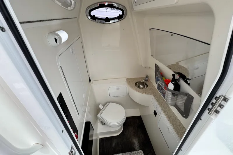 Slide: The Image of 2022 Regulator 28 boat interior bathroom with toilet, sink, and storage compartments. - 69