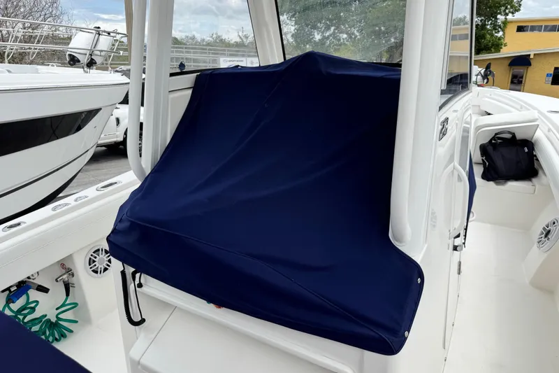 Slide: The Image of 2022 Regulator 28 boat interior with blue cover, showcasing seating and storage areas. - 70