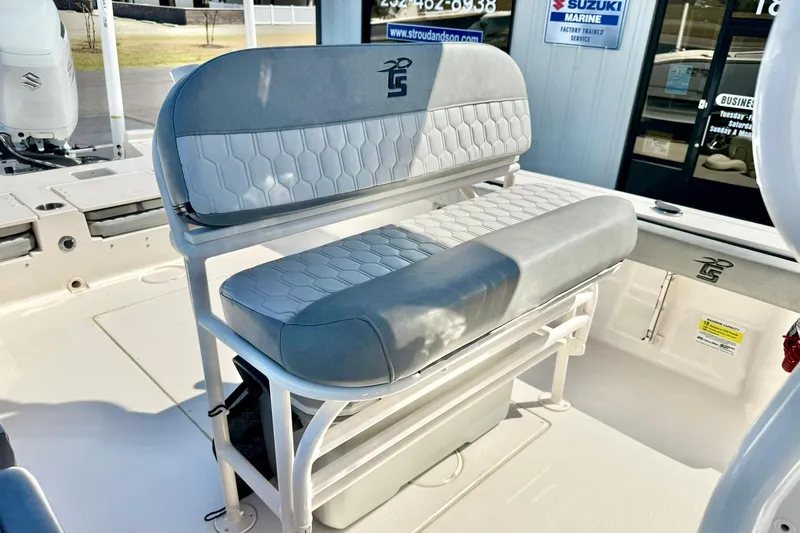 Slide: The Image of 2024 Carolina Skiff 26 Ultra Elite boat seating with gray upholstery and storage underneath. - 22