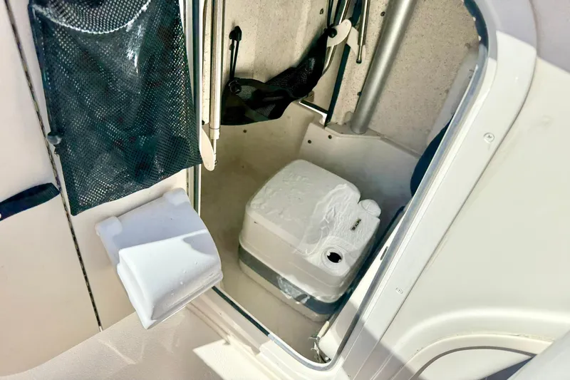 Slide: The Image of 2024 Carolina Skiff 26 Ultra Elite boat interior with portable toilet and storage. - 29