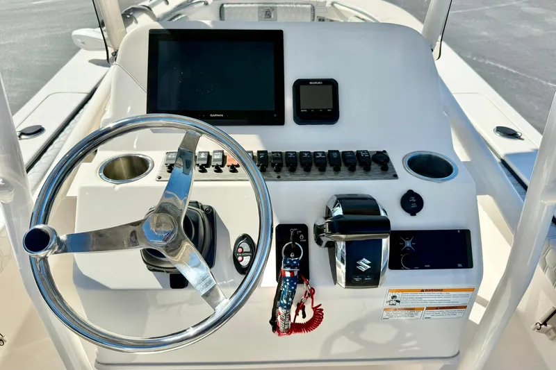 Slide: The Image of 2024 Carolina Skiff 26 Ultra Elite helm with steering wheel and control panel. - 3