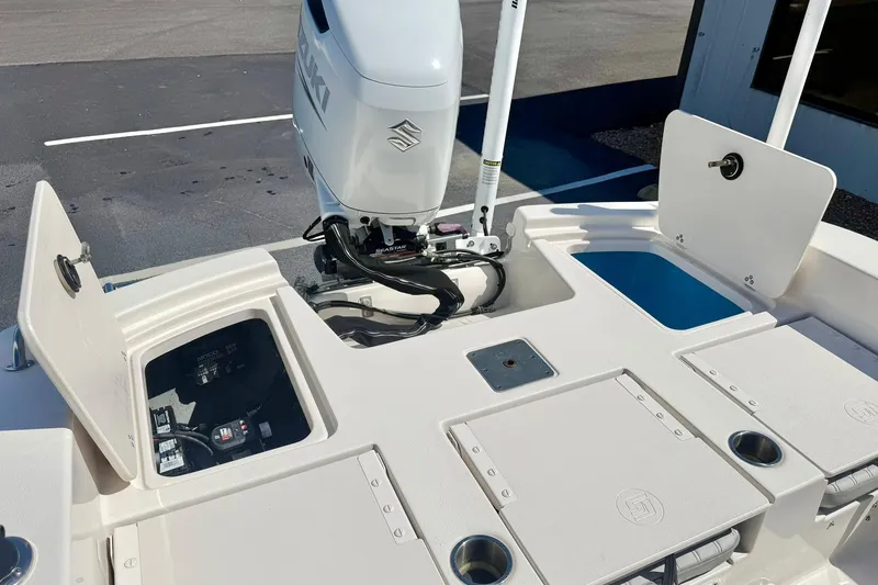 Slide: The Image of 2024 Carolina Skiff 26 Ultra Elite boat deck with Suzuki outboard motor and storage compartments. - 32
