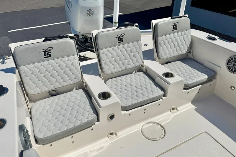 Slide: The Image of 2024 Carolina Skiff 26 Ultra Elite boat seating with gray cushioned seats and cup holders. - 35