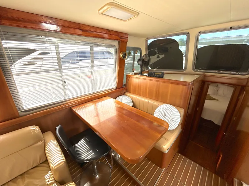 Slide: The Image of Interieur van een 2004 Mainship Trawler met houten tafel en zitgedeelte. - 34