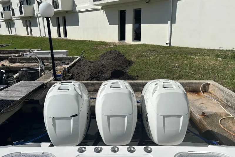 Slide: The Image of Triple outboard engines on a 2009 SeaHunter 40 Center Console boat docked near a building. - 10