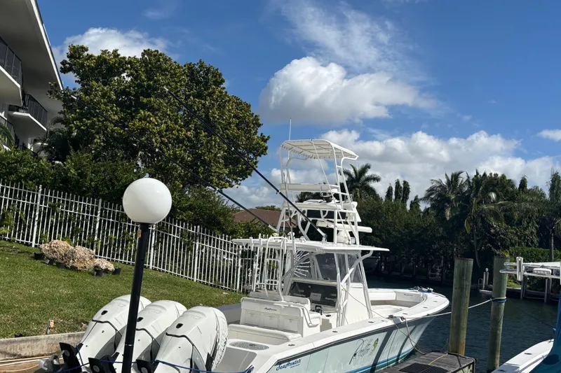 Slide: The Image of 2009 SeaHunter 40 Center Console boat docked under a clear blue sky. - 4
