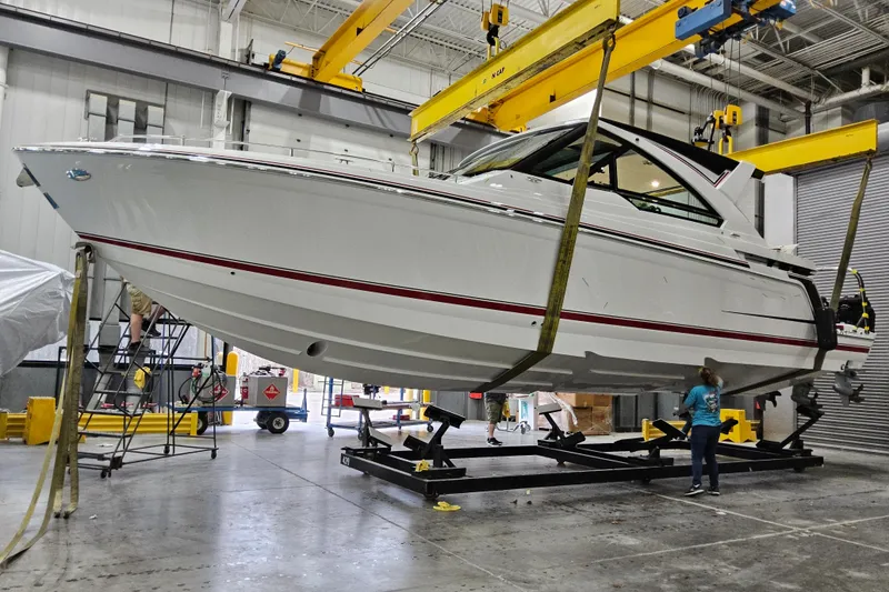 Slide: The Image of 2026 Formula 400 Super Sport Crossover boat in a workshop, suspended by cranes. - 29