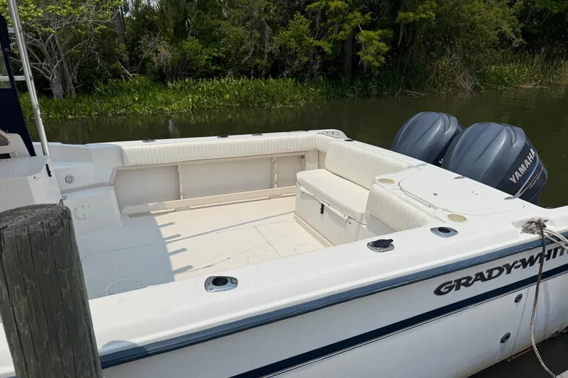 Slide: The Image of 1999 Grady-White Marlin 300 boat with Yamaha engines docked by lush greenery. - 10