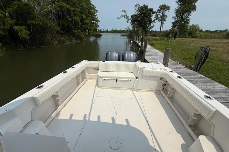 Slide: The Image of 1999 Grady-White Marlin 300 boat docked by a serene riverbank. - 11