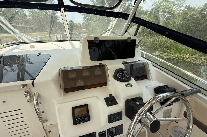 Slide: The Image of 1999 Grady-White Marlin 300 boat cockpit with steering wheel and navigation instruments. - 18
