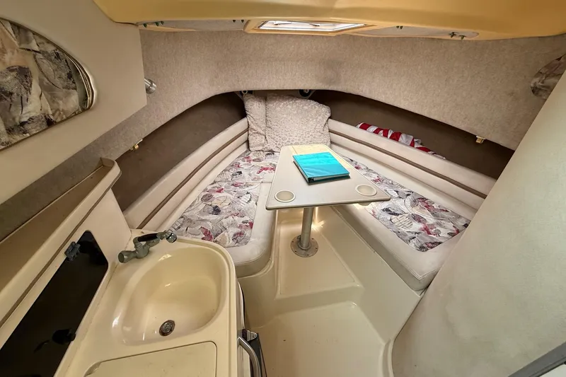 Slide: The Image of 1999 Grady-White Marlin 300 cabin interior with seating, table, and sink. - 21