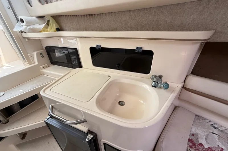 Slide: The Image of 1999 Grady-White Marlin 300 boat interior with sink, microwave, and storage. - 22