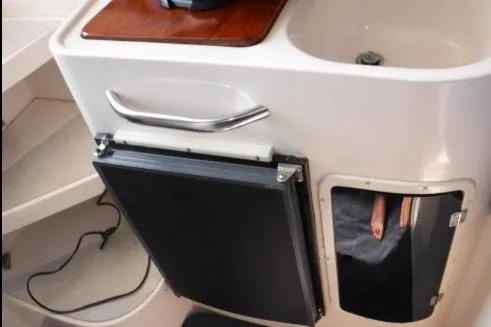 Slide: The Image of Interior view of a 1999 Grady-White Marlin 300 boat, featuring a compact kitchenette area. - 23