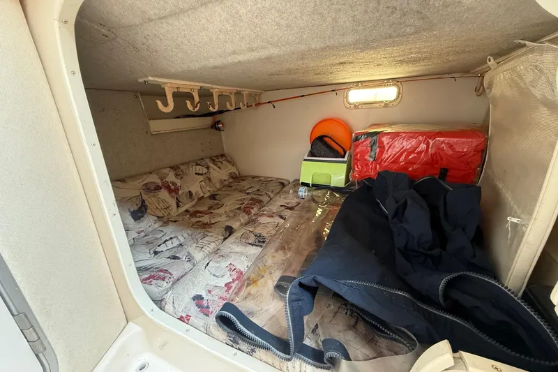 Slide: The Image of 1999 Grady-White Marlin 300 cabin interior with storage and bedding. - 26