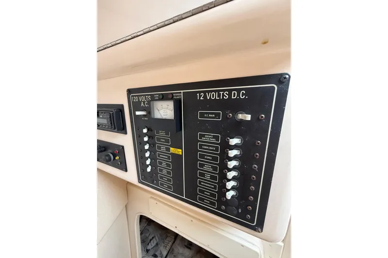 Slide: The Image of Electrical panel of a 1999 Grady-White Marlin 300 boat, featuring AC and DC switches. - 28