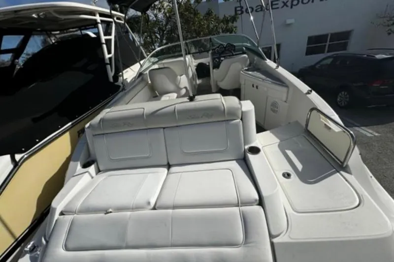 Slide: The Image of 2012 Sea Ray 260 Sundeck boat interior with seating and helm, parked outdoors. - 11