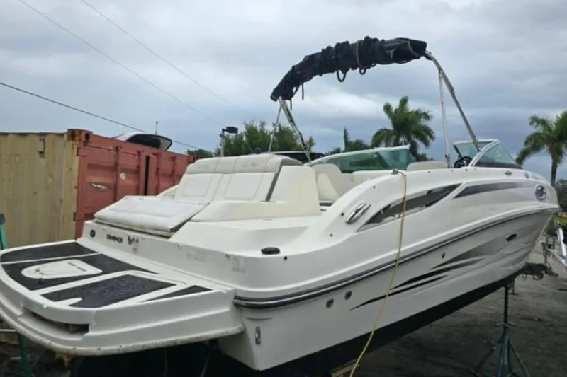 Slide: The Image of 2012 Sea Ray 260 Sundeck boat with white exterior, docked outdoors. - 7