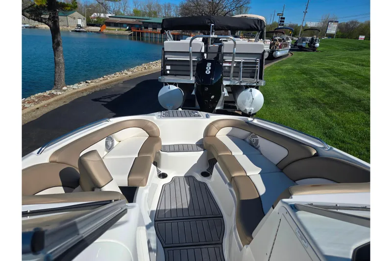 Slide: The Image of 2011 Yamaha Boats SX240 HO interior with beige seating, docked near a lake. - 17