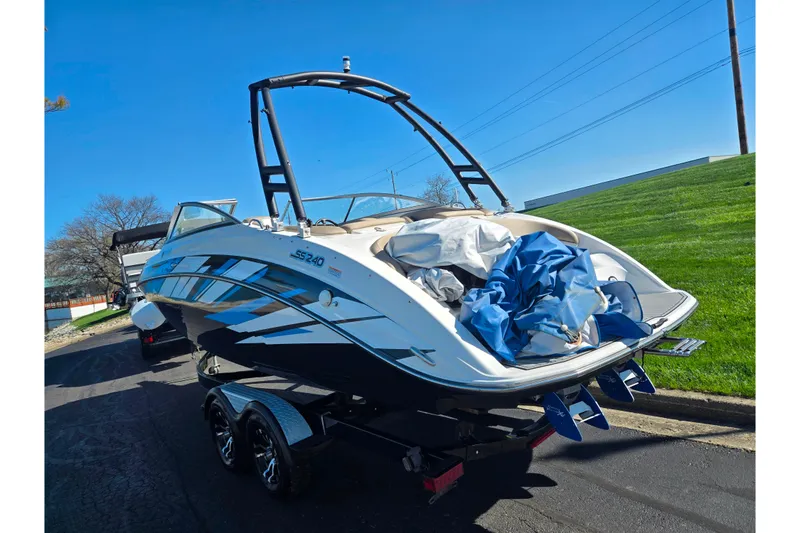 Slide: The Image of 2011 Yamaha Boats SX240 HO on trailer, parked outdoors under clear blue sky. - 3
