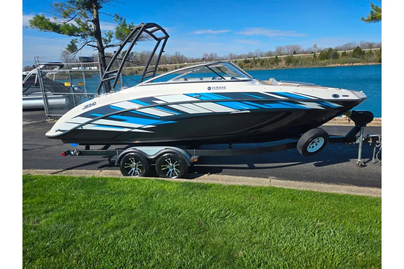 Slide: The Image of 2011 Yamaha Boats SX240 HO on trailer by a lake, showcasing sleek design. - 9