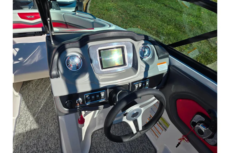 Slide: The Image of 2016 Chaparral Vortex 203 VRX boat dashboard with steering wheel and control panel. - 12