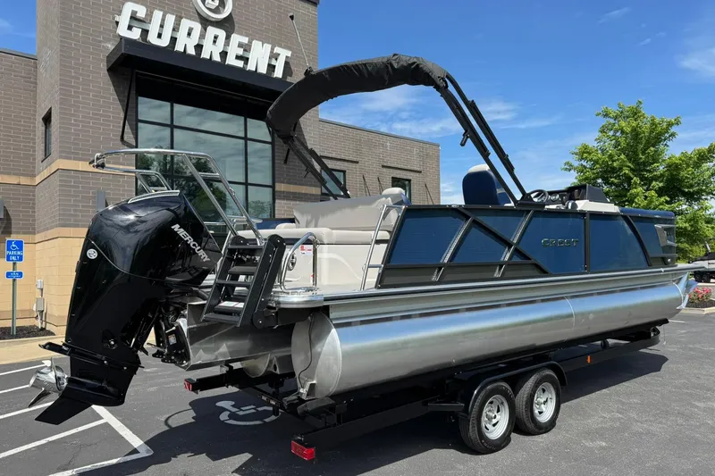 Slide: The Image of 2024 Crest Caribbean LX 230 pontoon boat on trailer outside dealership. - 4