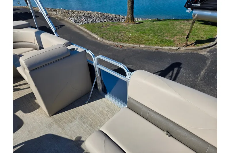 Slide: The Image of 2020 Avalon Venture Cruise Bow Fish boat interior with beige seating by a lake. - 12