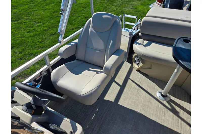 Slide: The Image of 2020 Avalon Venture Cruise Bow Fish boat interior with beige seating and steering wheel. - 14