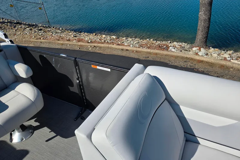 Slide: The Image of 2022 Crest Classic LX 220 SLRC boat interior with plush seating by a serene lakeside. - 12