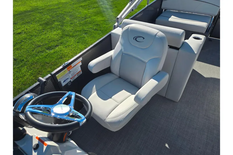 Slide: The Image of 2022 Crest Classic LX 220 SLRC boat interior with plush captain's chair and steering wheel. - 14