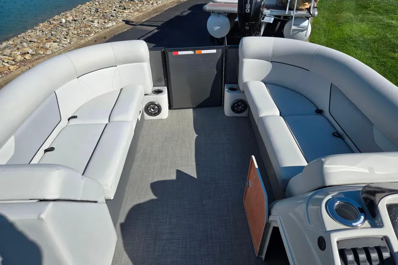 Slide: The Image of 2022 Crest Classic LX 220 SLRC pontoon boat interior with plush seating and speakers. - 22