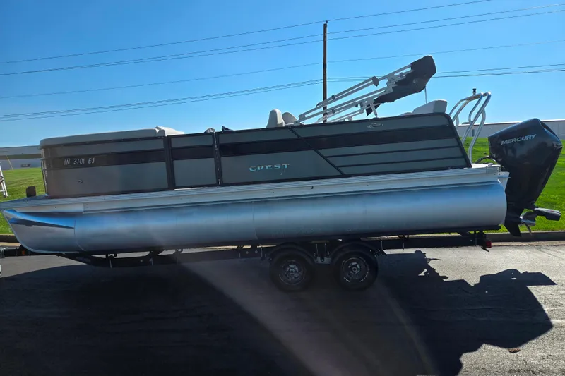 Slide: The Image of 2022 Crest Classic LX 220 SLRC pontoon boat on trailer, side view, sunny day. - 4