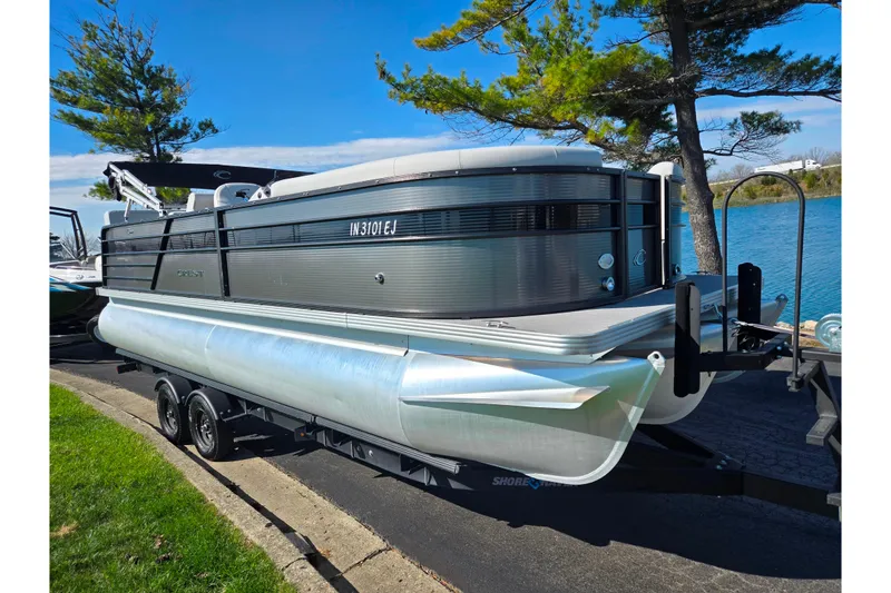 Slide: The Image of 2022 Crest Classic LX 220 SLRC pontoon boat on trailer by a lake. - 8