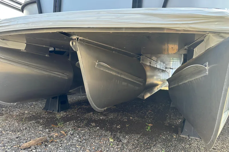 Slide: The Image of Underneath view of 2026 Godfrey Sweetwater 2286 SFL pontoon boat on gravel. - 2