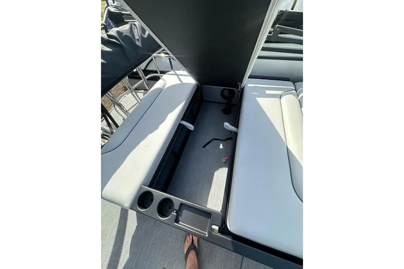 Slide: The Image of Open storage compartment on 2026 Godfrey Sweetwater 2286 SFL boat with cup holders. - 24