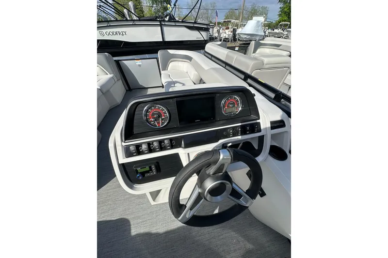 Slide: The Image of 2026 Godfrey Sweetwater 2286 SFL boat dashboard with steering wheel and control panel. - 7