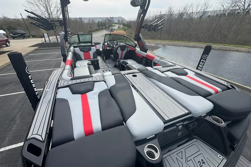 Slide: The Image of 2022 MasterCraft XT24 boat interior with sleek seating and modern design near a waterfront. - 14