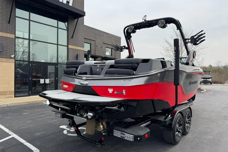 Slide: The Image of 2022 MasterCraft XT24 boat in red and black, parked outside a modern building. - 4