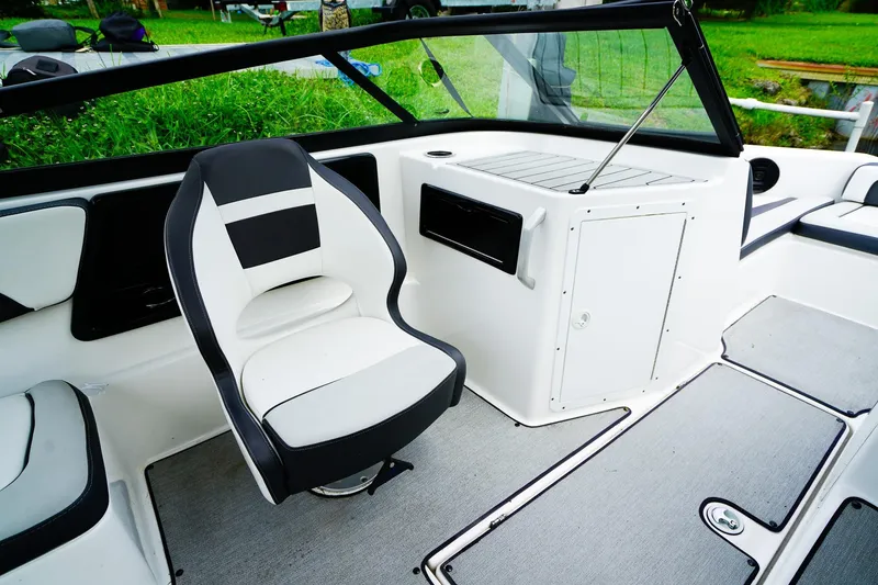 Slide: The Image of 2023 Yamaha Boats SX195 interior with sleek seating by a scenic canal. - 10
