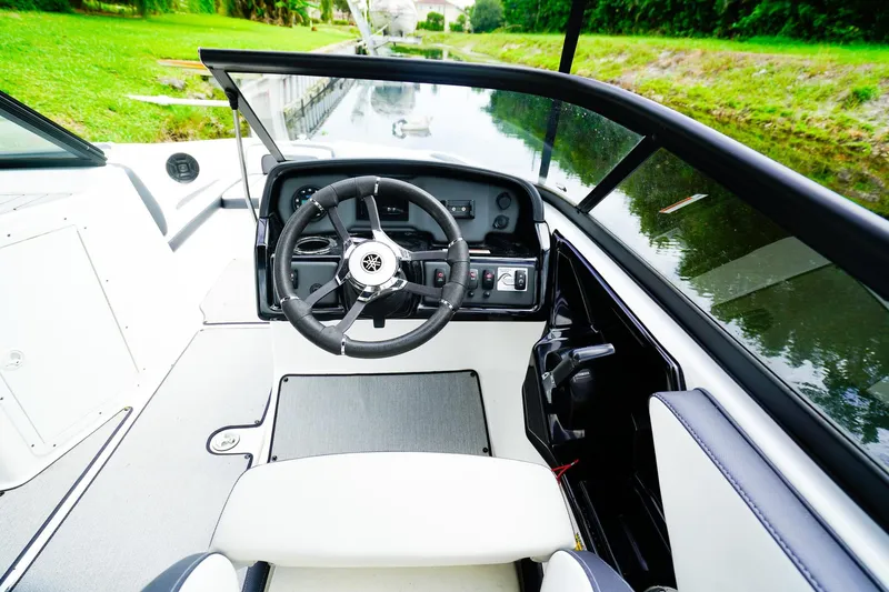 Slide: The Image of 2023 Yamaha Boats SX195 cockpit with steering wheel and captain's chair. - 13