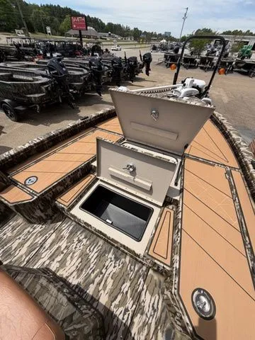 Slide: The Image of Avid 21 MAG ST 2026 boat with open storage hatch on a parking lot. - 19