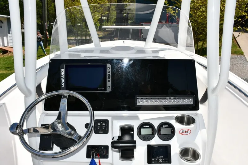 Slide: The Image of 2023 Tidewater 210 LXF boat dashboard with steering wheel and electronic controls. - 13