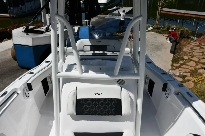 Slide: The Image of 2023 Tidewater 210 LXF boat interior with seating and console, dockside view. - 15