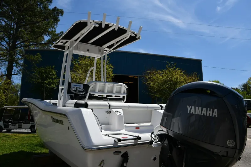 Slide: The Image of 2023 Tidewater 210 LXF boat with Yamaha engine, parked outdoors near a blue building. - 3