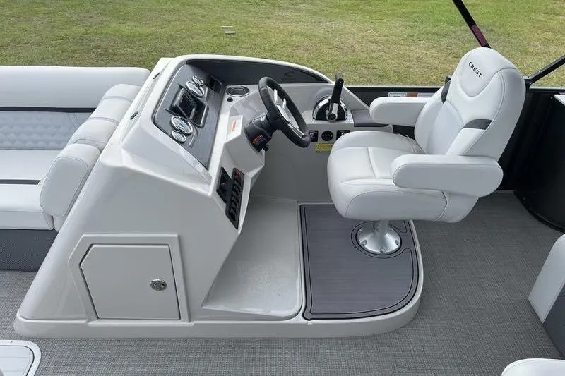Slide: The Image of 2024 Crest Classic Platinum 240 SLC boat helm with plush captain's chair and control panel. - 10