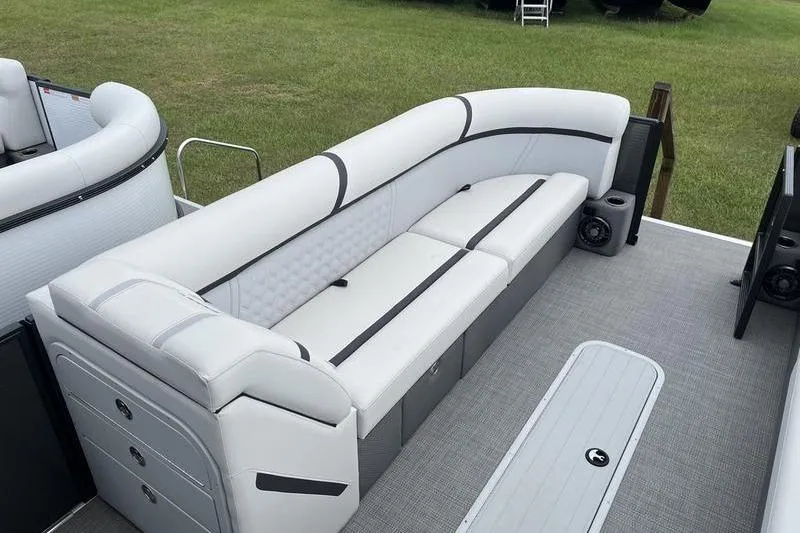 Slide: The Image of 2024 Crest Classic Platinum 240 SLC pontoon boat with luxurious seating on grassy background. - 17
