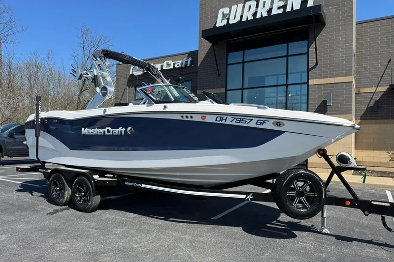 The Image of 2021 MasterCraft X24 boat on trailer outside dealership. - 1
