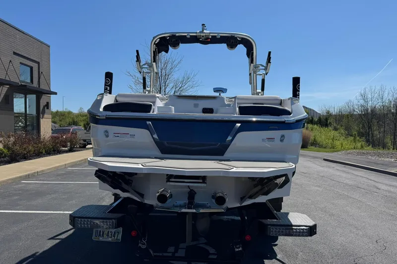Slide: The Image of 2021 MasterCraft X24 boat rear view in parking lot under clear blue sky. - 4