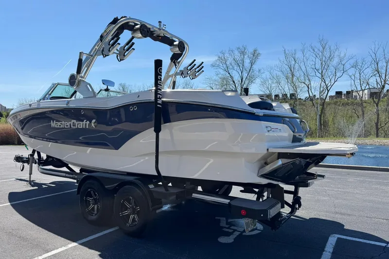 Slide: The Image of 2021 MasterCraft X24 boat on trailer in parking lot, sunny day. - 5